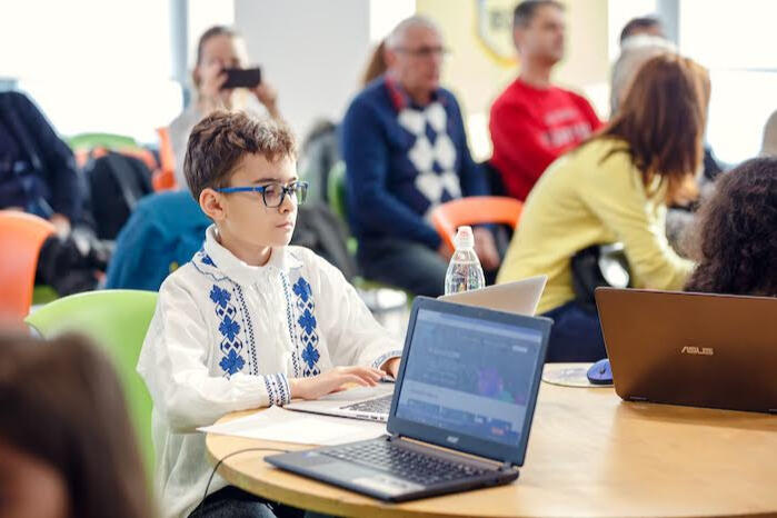 Elevi lucrând la calculatoare în cadrul clubului